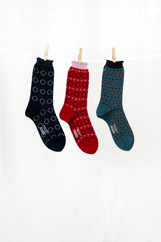 Three patterned socks hanging on a white background